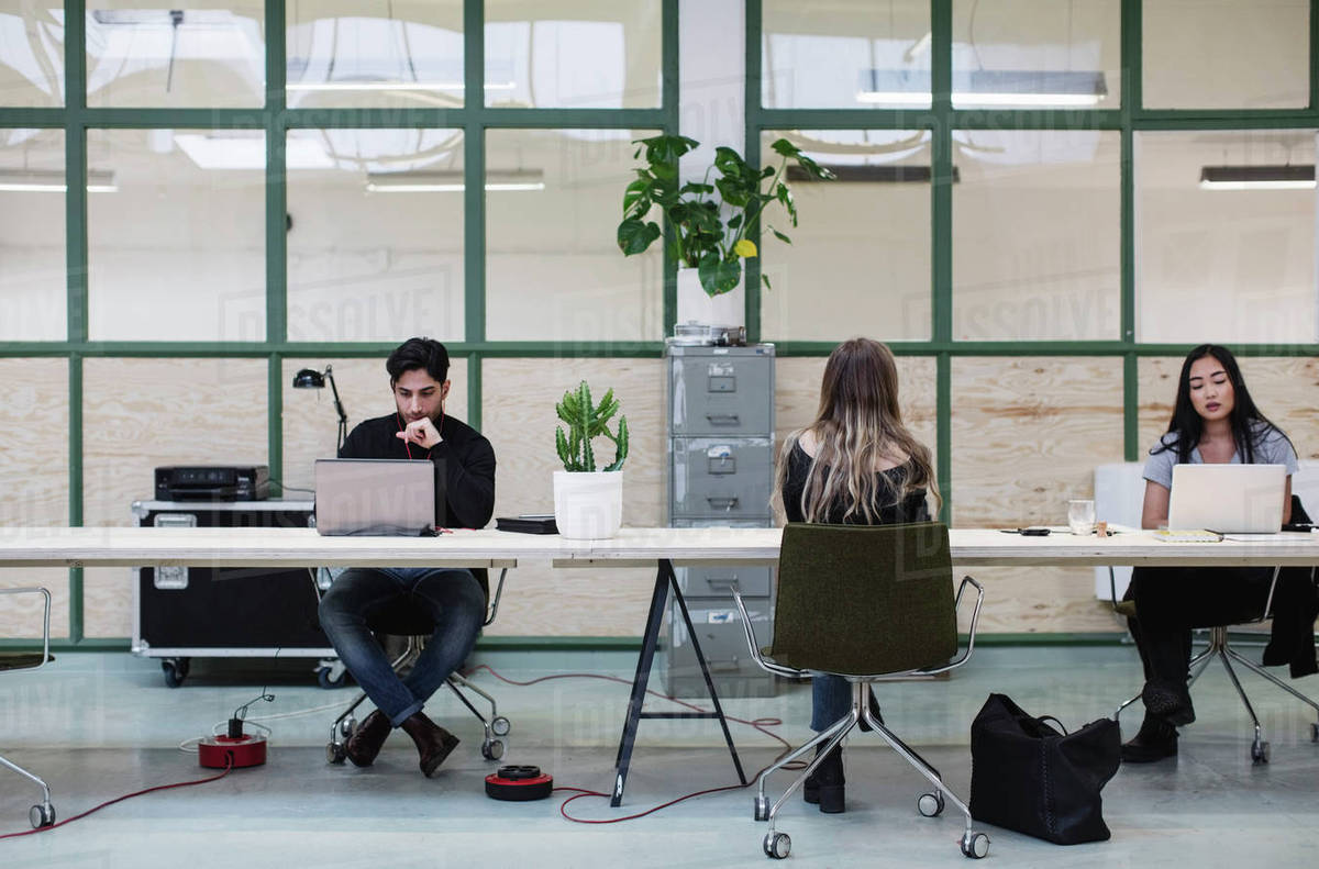 Two women and one man working at desk in creative office Royalty-free stock photo