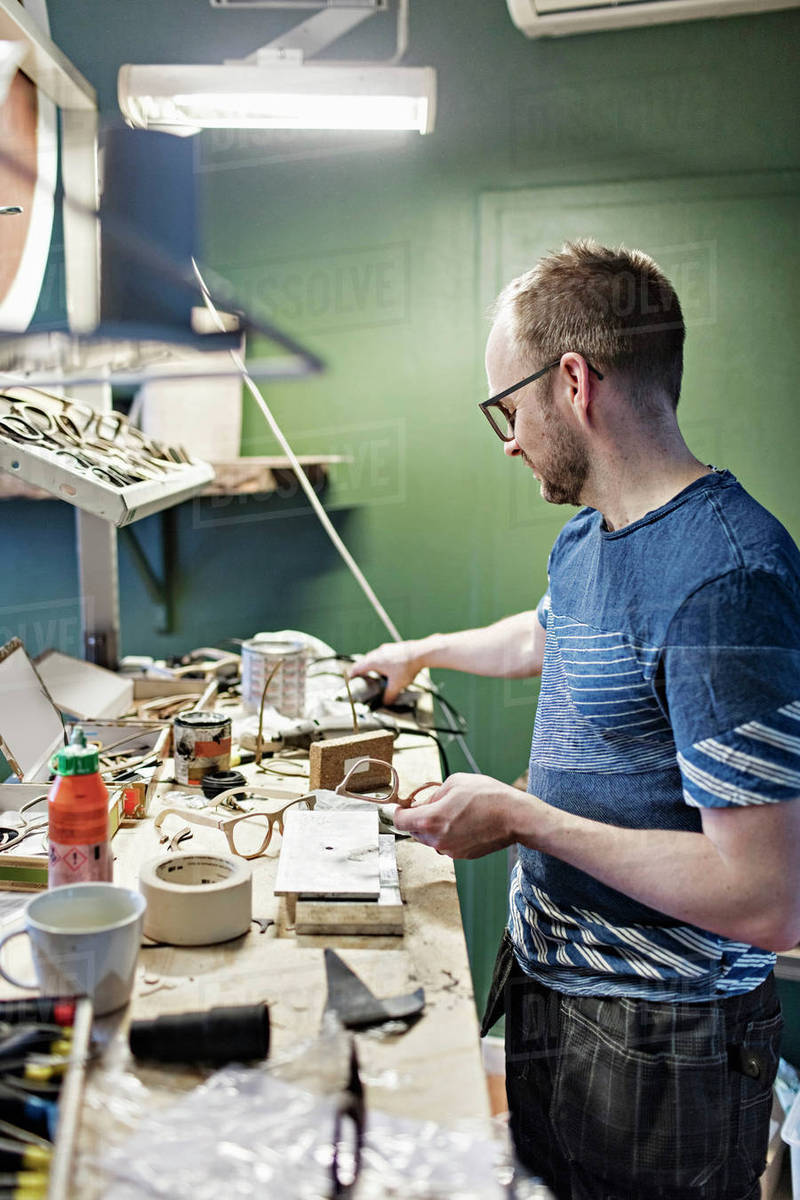 Side view of male owner working in eyewear Stock Photo Dissolve