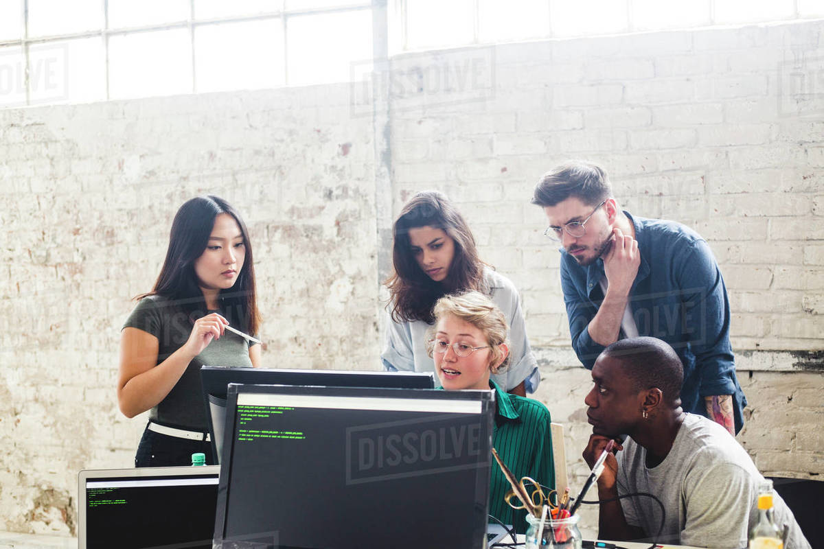 Confident young professionals planning while coding in computer at workplace Royalty-free stock photo