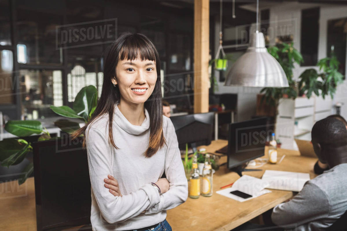 Portrait of smiling businesswoman with arms crossed at workplace Royalty-free stock photo