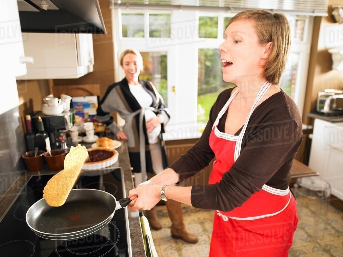 Pregnant women making pancakes Stock Photo Dissolve