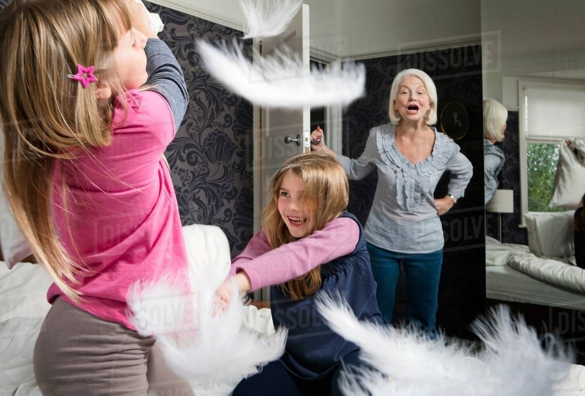 A Granny Shouts At Girls Pillow Fighting Stock Photo Dissolve