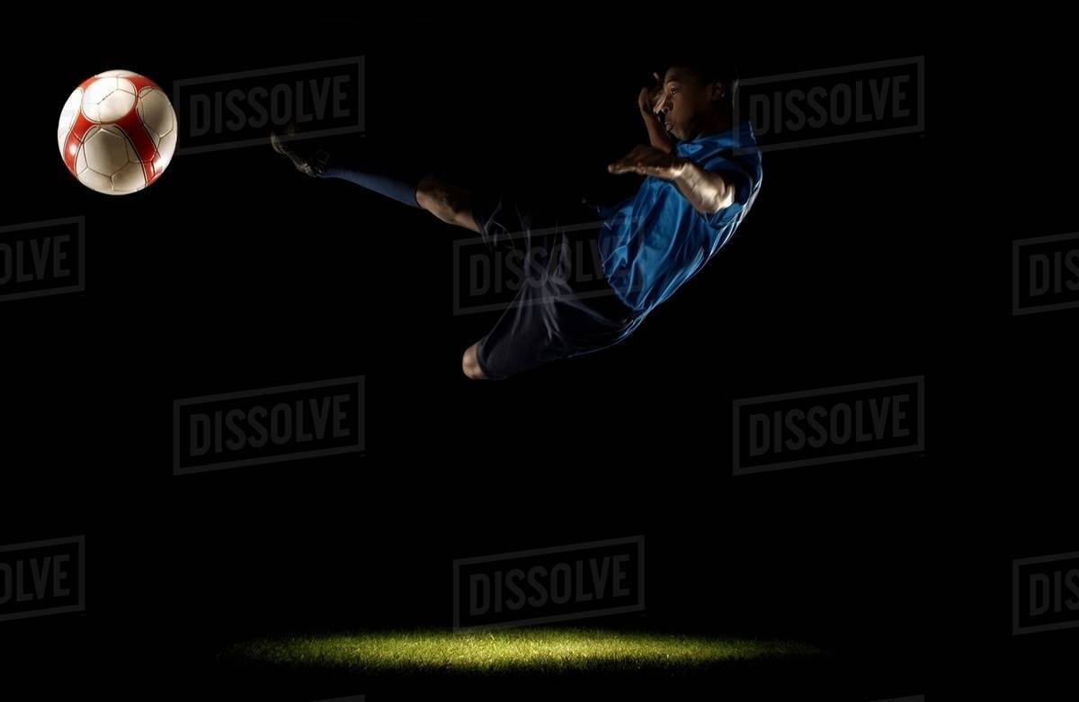 Footballer doing scissors kick Stock Photo Dissolve