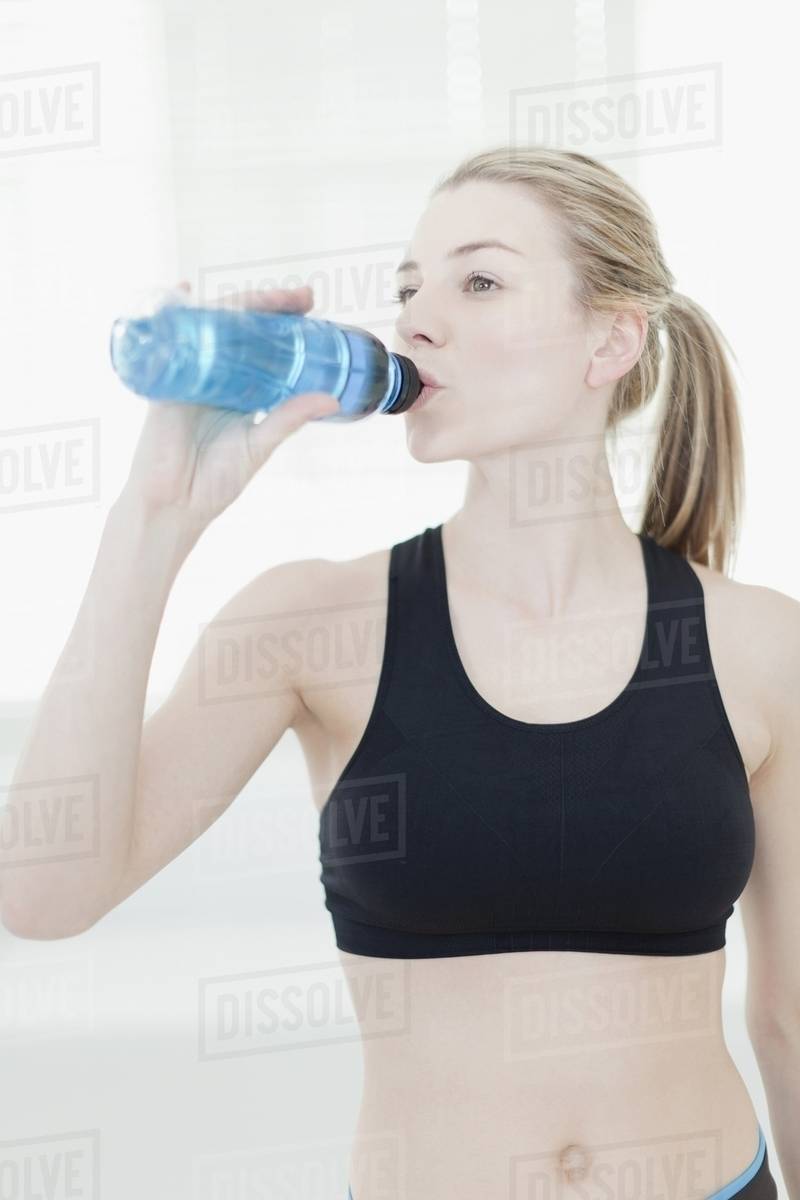 Woman drinking water during workout Stock Photo Dissolve