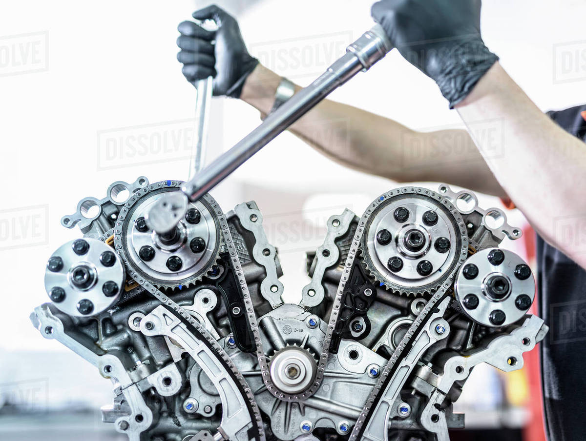 Engineer working on engine in racing car factory, close up Stock