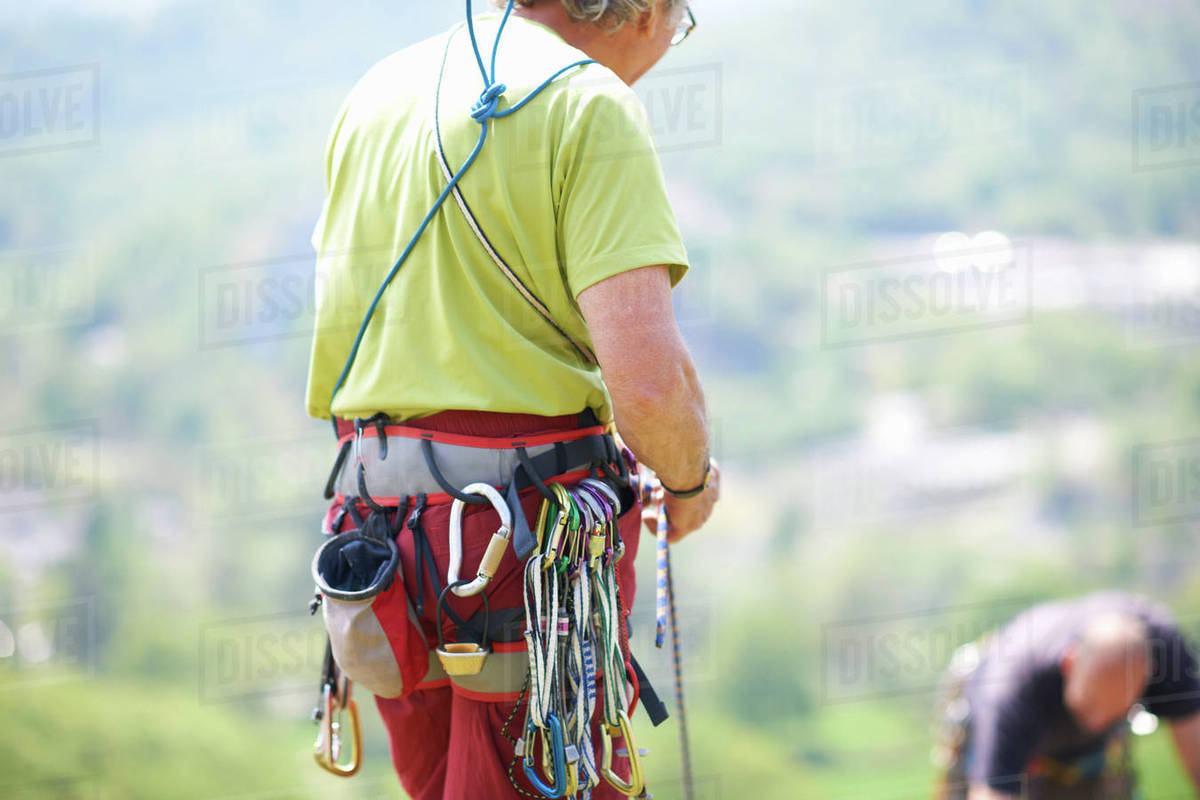 Rear view of rock climber wearing safety harness Stock Photo Dissolve
