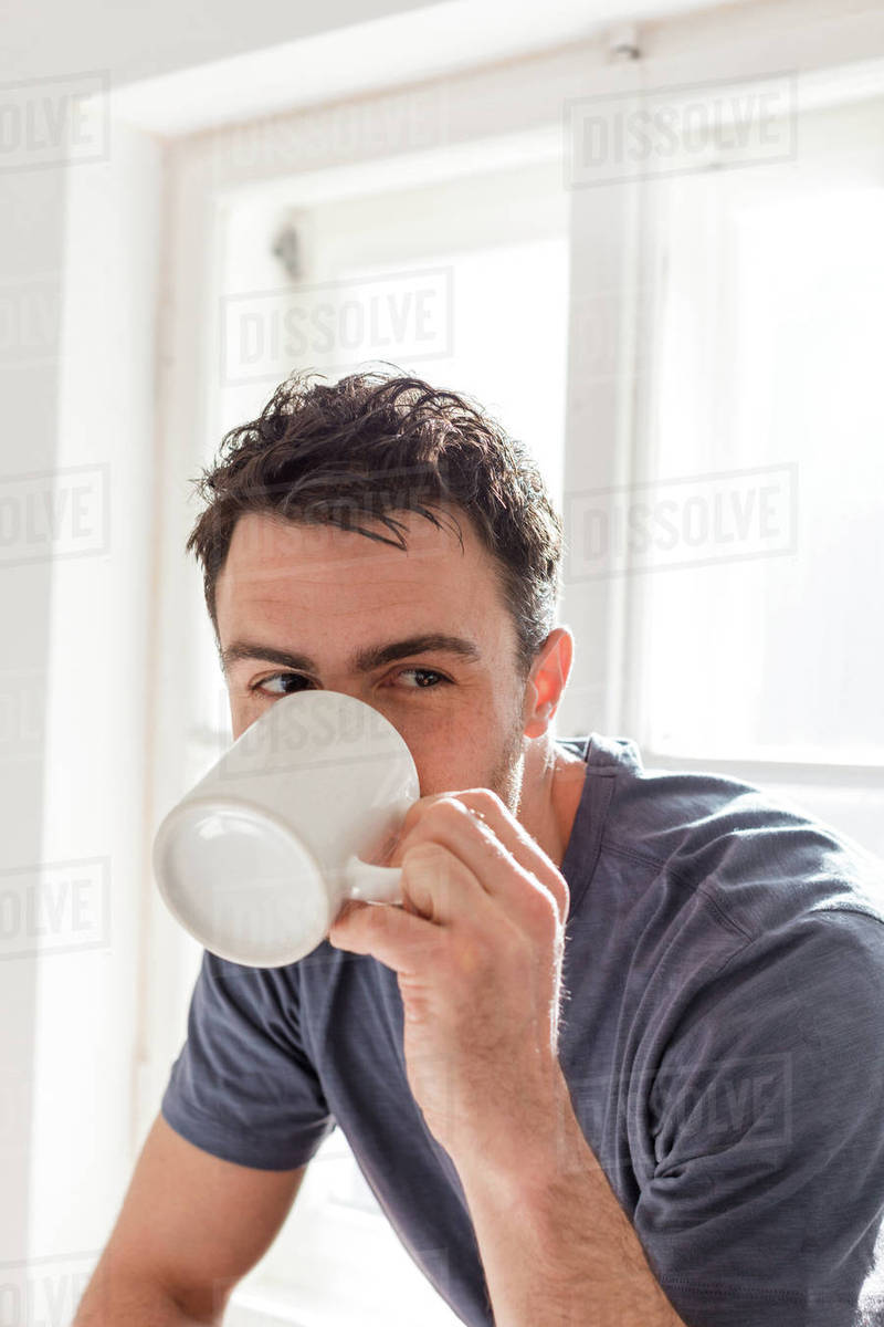 Man drinking from mug Stock Photo Dissolve