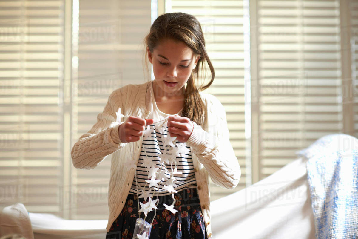 Girl untangling star shape decorative lights Stock Photo Dissolve