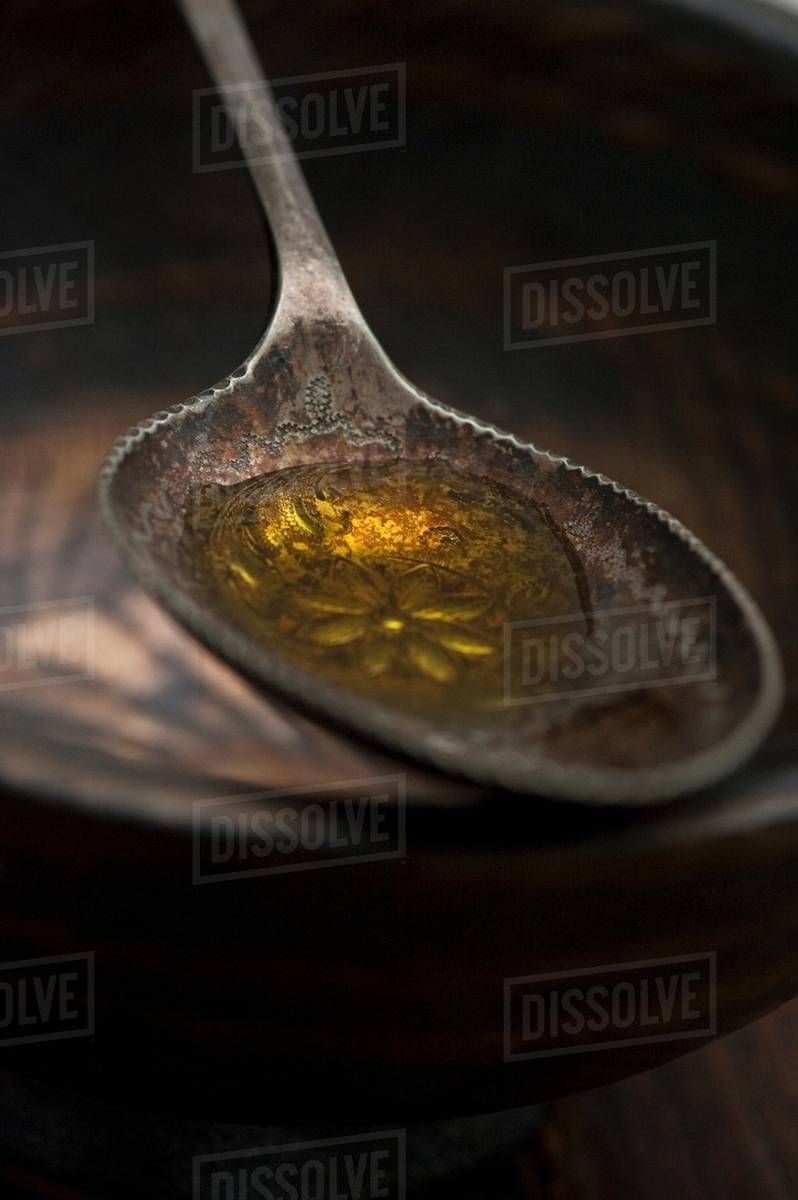 Close up of spoonful of olive oil Stock Photo Dissolve