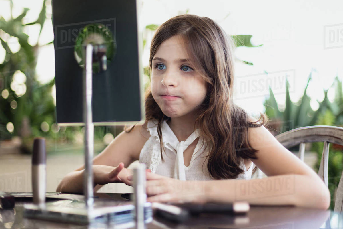 Girl pursing lips in front of mirror Stock Photo Dissolve