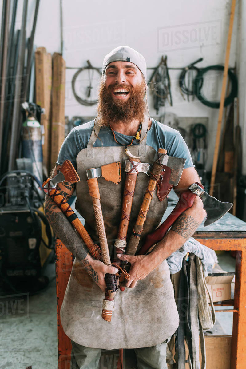 Axe maker showing off variety of handcrafted axes Stock Photo Dissolve