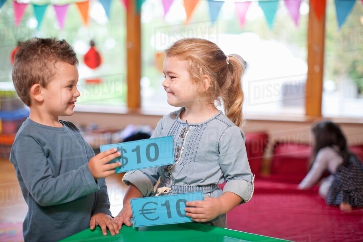 Boy and girl counting euro currency at nursery school Stock Photo