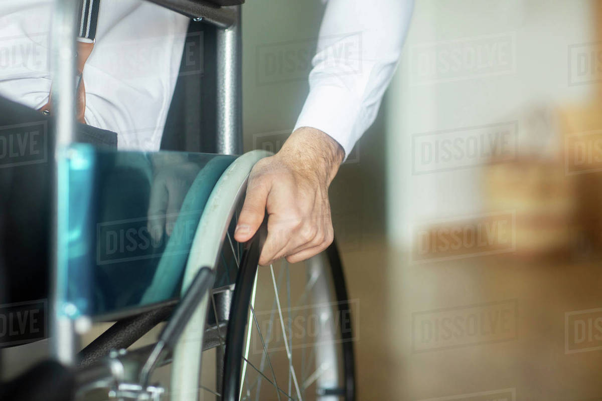 Hand on wheel of wheelchair Stock Photo Dissolve