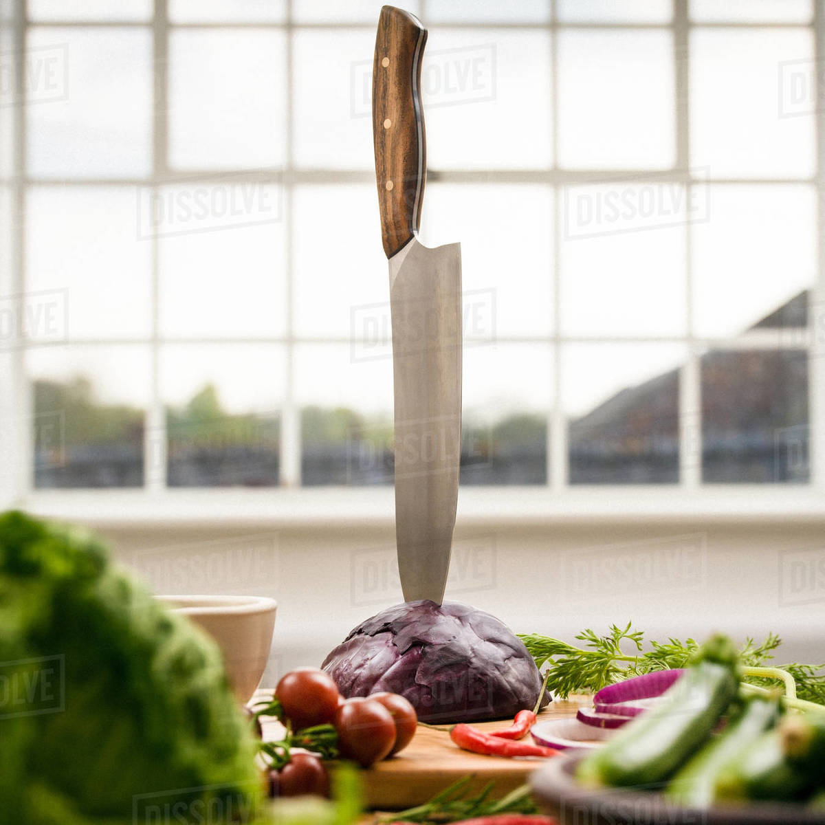 Kitchen knife stuck in red cabbage on kitchen counter, still life