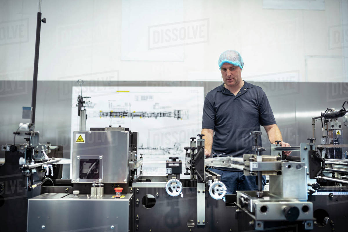 Worker adjusting printing machine in print factory Royalty-free stock photo