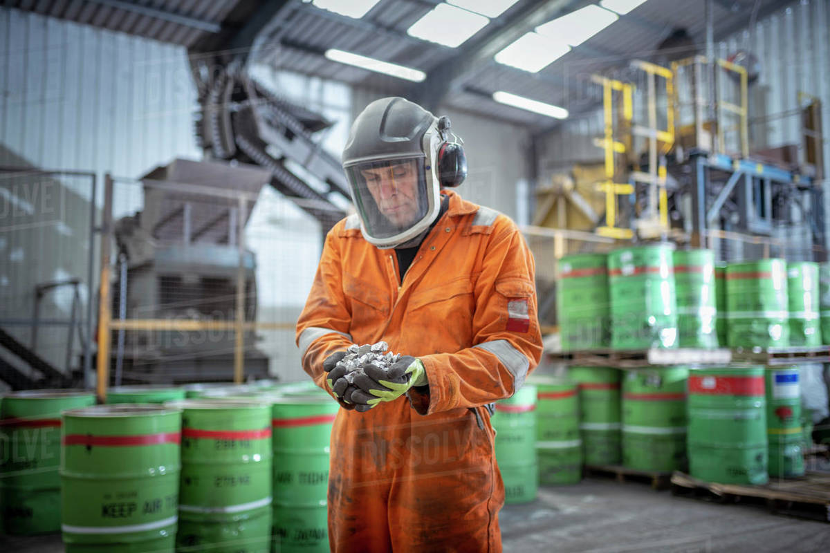Worker holding titanium sample in crushing plant in titanium recycling plant Royalty-free stock photo