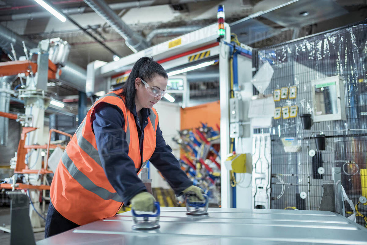 Female worker assembling vehicle roofs in car factory Royalty-free stock photo