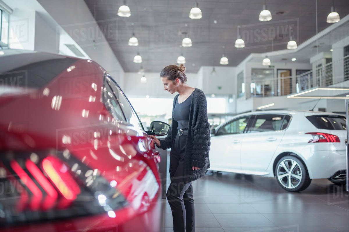 Female customer inspecting new car in car showroom Royalty-free stock photo