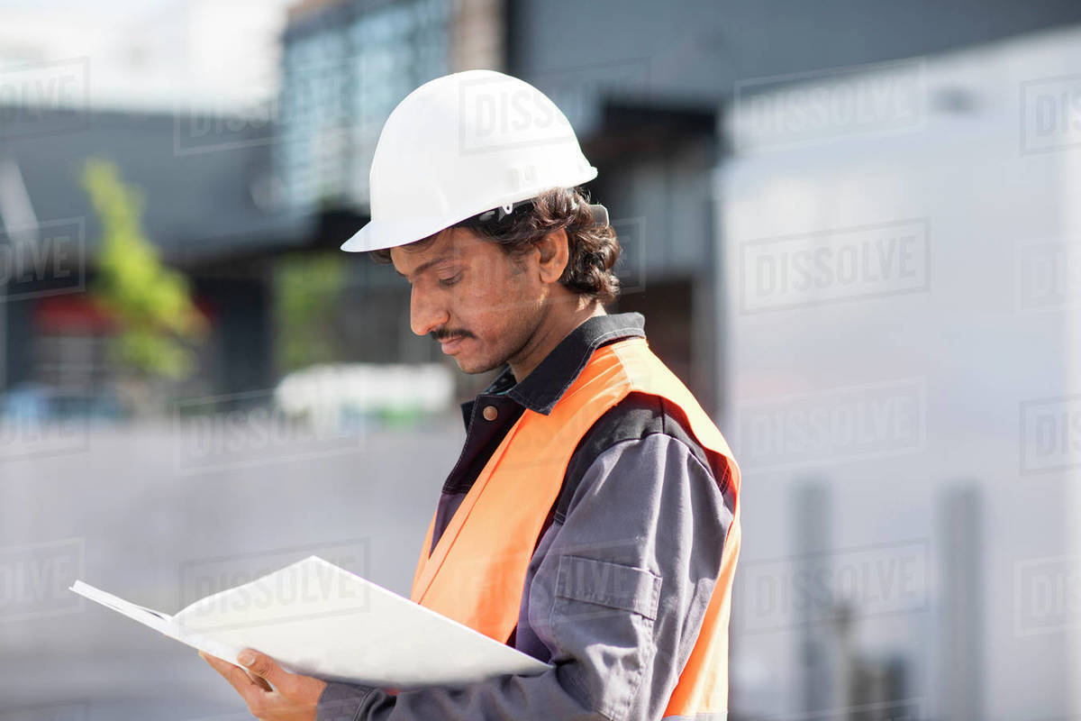 Male engineer looking at plans by industrial building Royalty-free stock photo