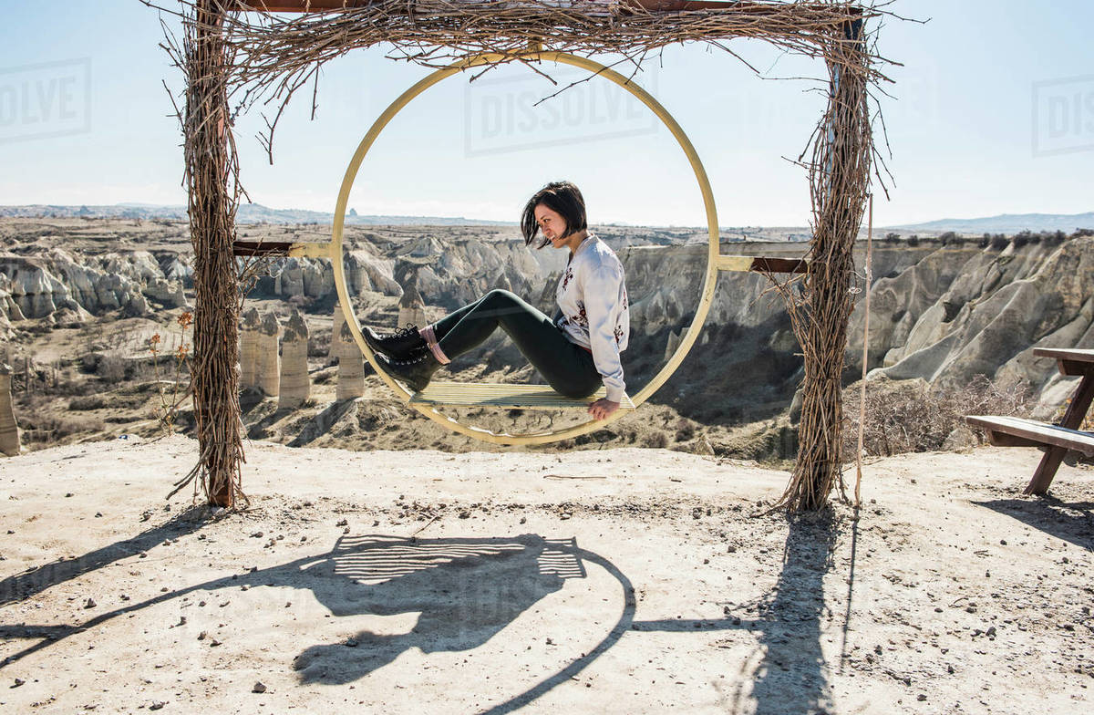 Woman playing on circular swing overlooking fairy chimney valley, Göreme, Cappadocia, Nevsehir, Turkey Royalty-free stock photo