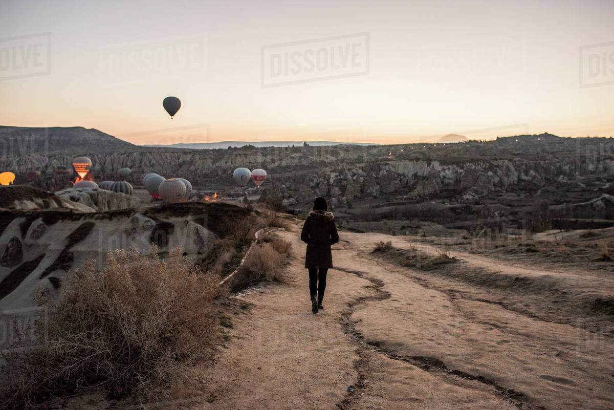 Woman enjoying view and display of hot air balloons in valley, Göreme, Cappadocia, Nevsehir, Turkey Royalty-free stock photo