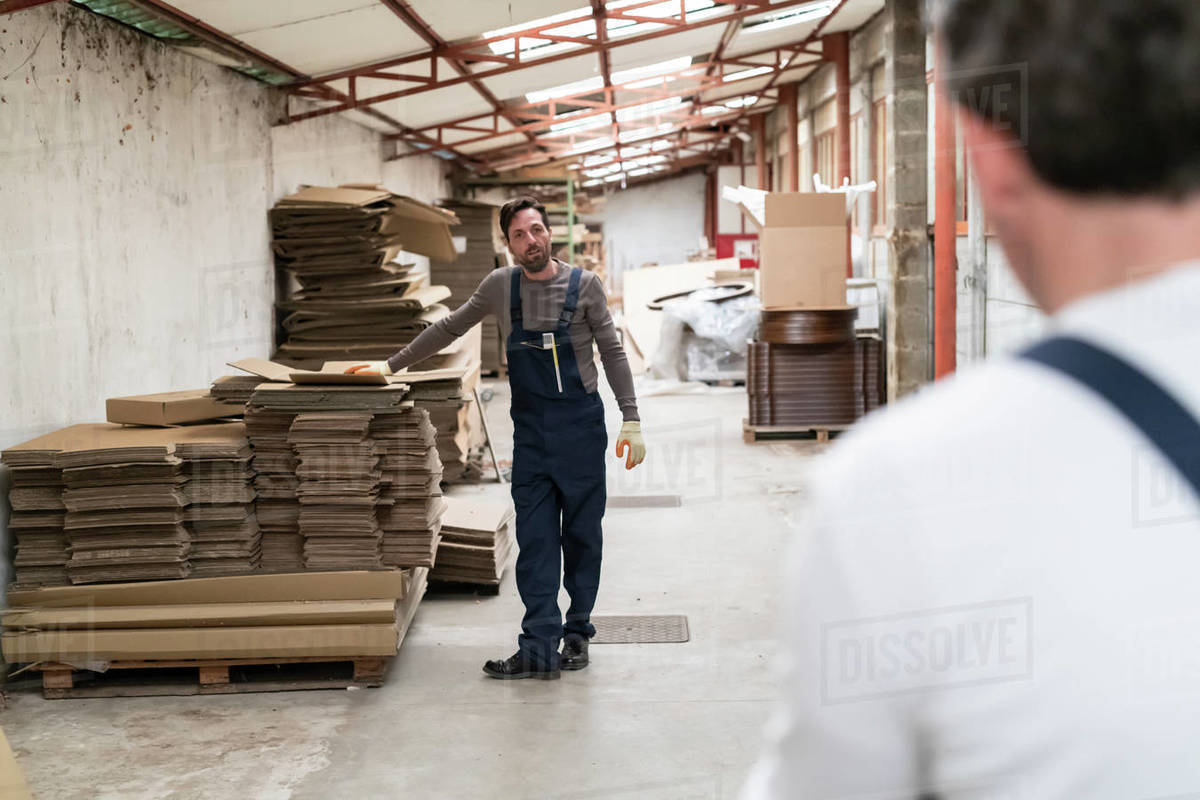 Worker resting hand on stack of cardboard boxes in factory Royalty-free stock photo