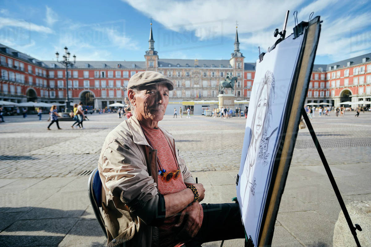 Mature male street artist by drawing canvas in town square, portrait, Madrid, Spain Royalty-free stock photo