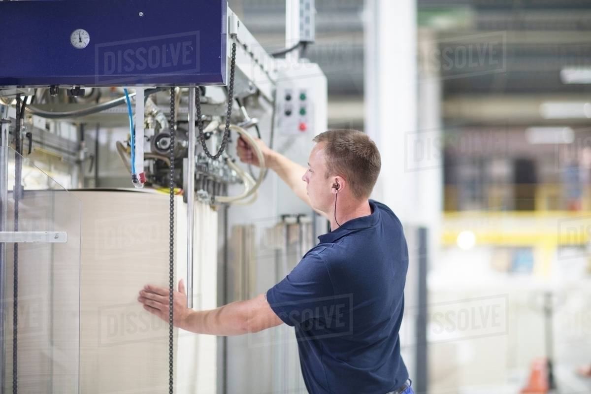 Worker using machine in paper packaging factory Stock Photo Dissolve