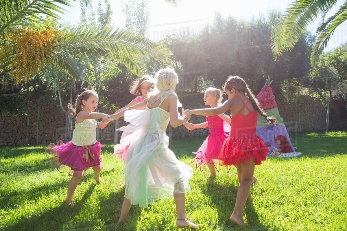 Five energetic girls in fairy costume playing in garden Royalty-free stock photo