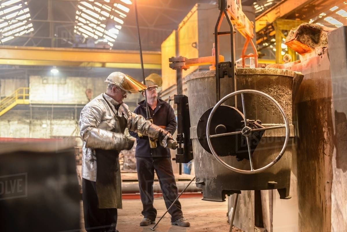 Workers preparing flask for pouring molten metal in foundry Stock