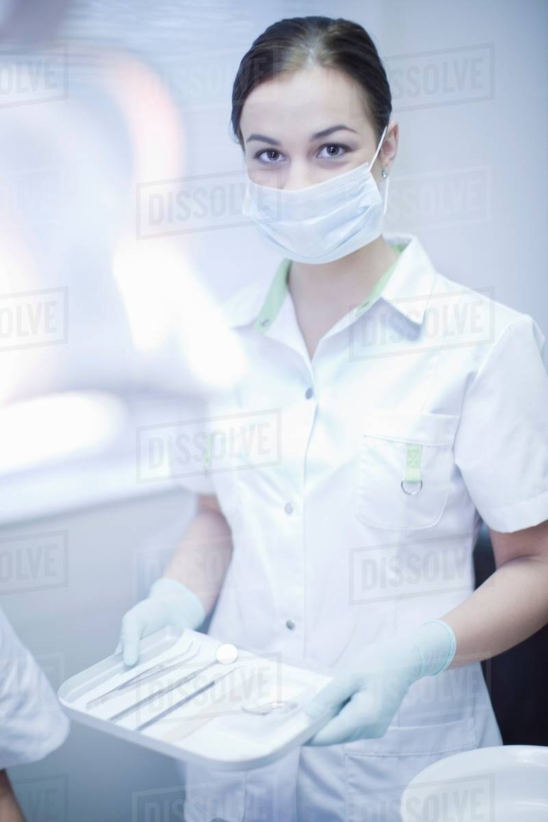 Portrait of female dental nurse holding surgical tray Stock Photo