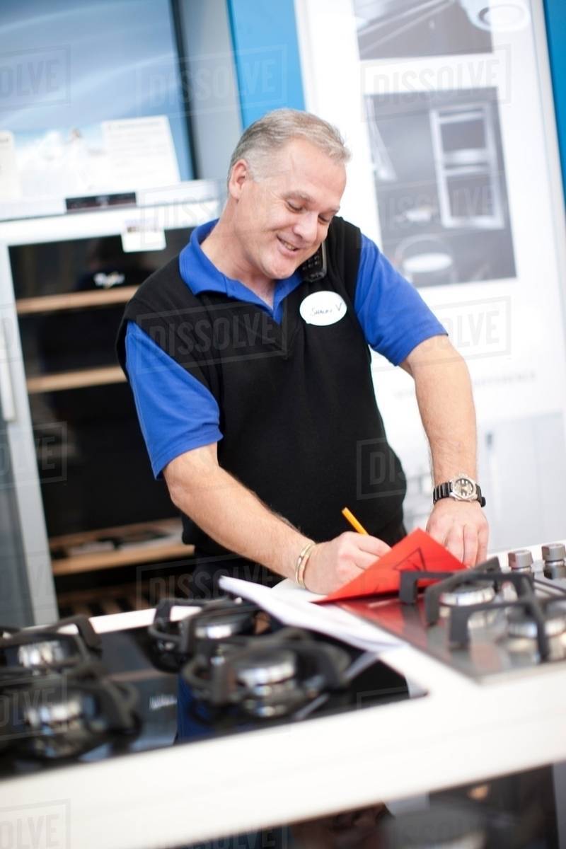 Kitchen appliance salesman in showroom Stock Photo Dissolve