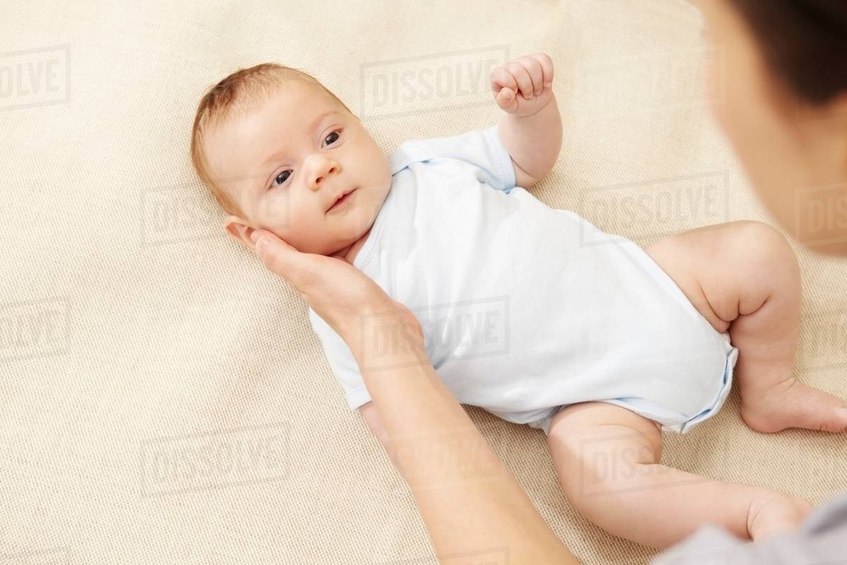 Mother touching baby boy's cheek Stock Photo Dissolve