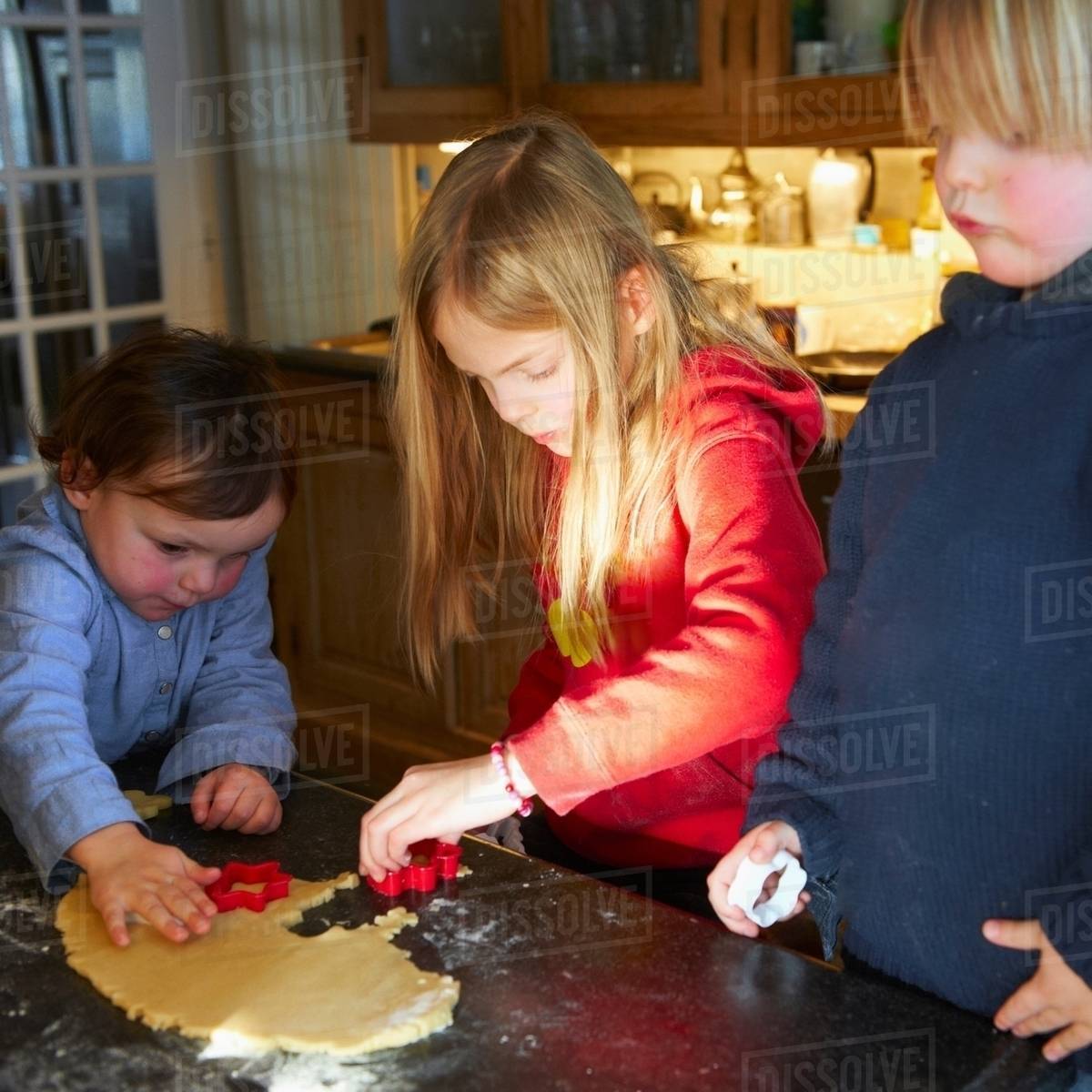 Brother and sisters making biscuits in kitchen Stock Photo Dissolve