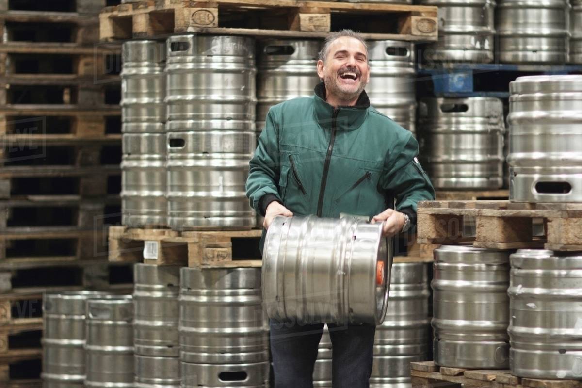 Brewery worker carrying barrel Stock Photo Dissolve