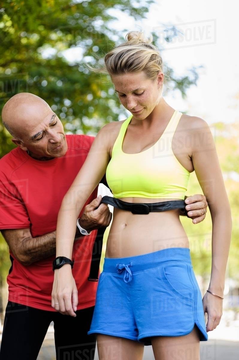 Personal trainer checking athletes heart rate monitors Stock Photo