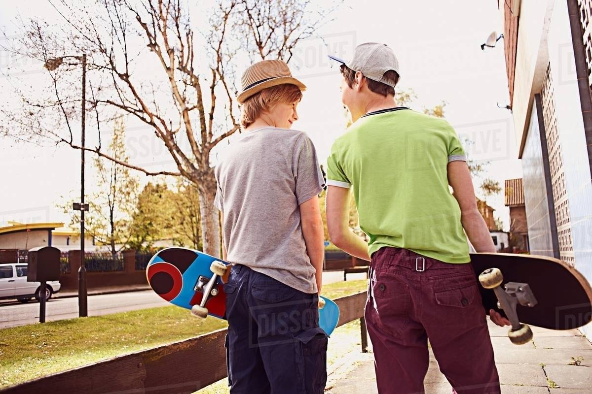 Boys carrying skateboards Stock Photo Dissolve