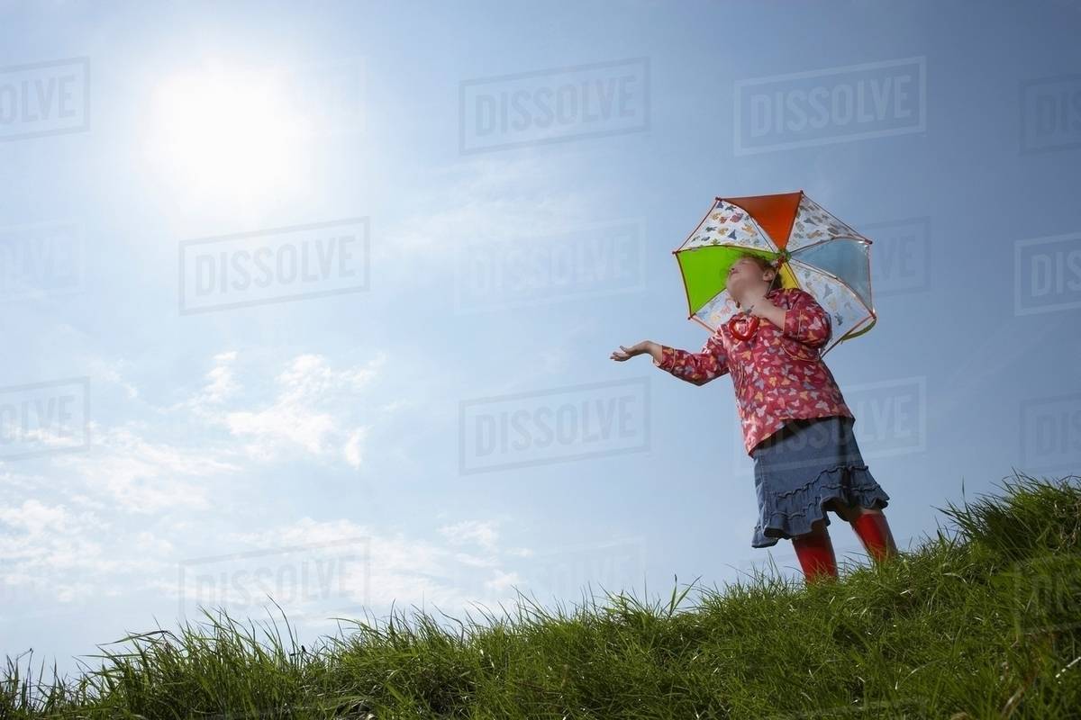 Girl using umbrella on sunny day - Royalty-free Stock Photo | Dissolve