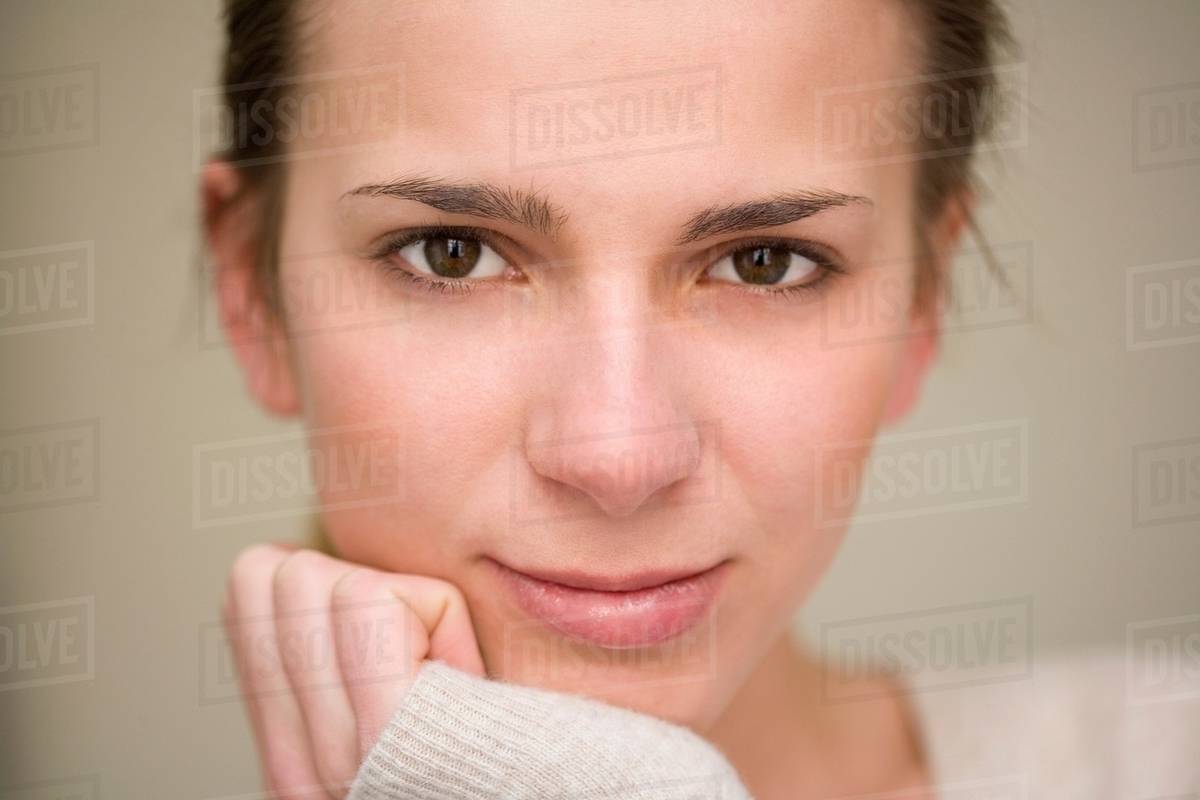 Woman resting chin in hand Stock Photo Dissolve