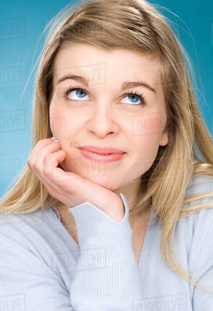 Smiling girl resting chin in hand Stock Photo Dissolve