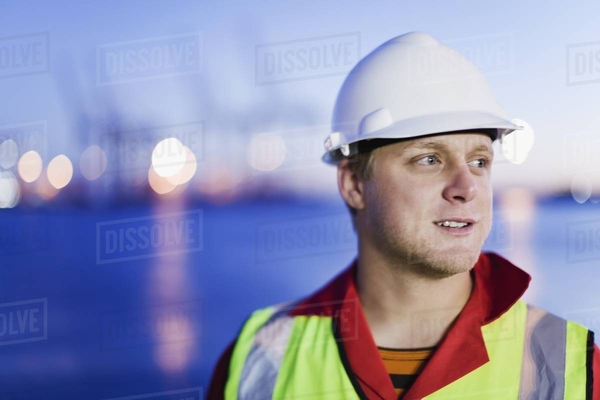 Worker wearing hard hat in shipyard Stock Photo Dissolve