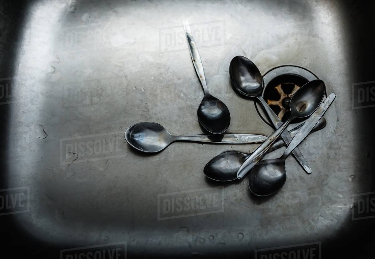 Pile of dirty spoons in sink Stock Photo Dissolve