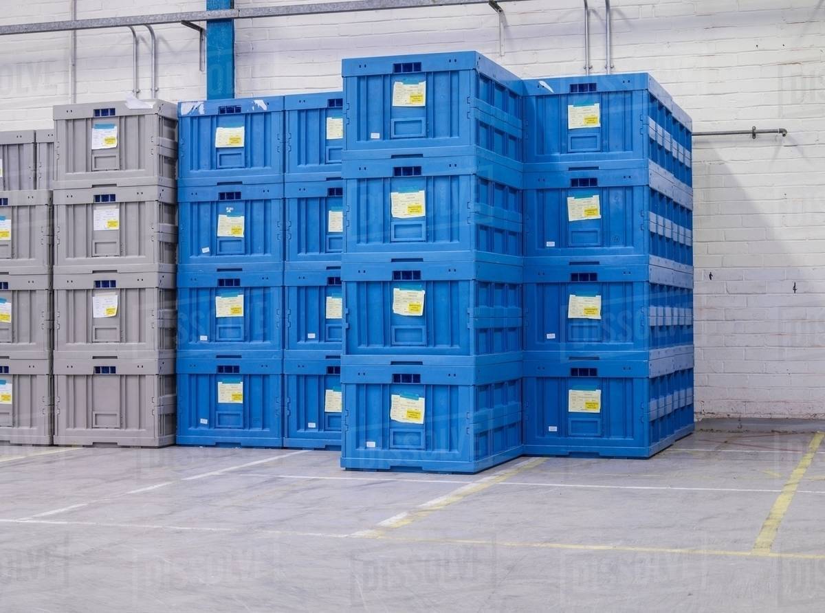 Stacked blue crates in factory Stock Photo Dissolve