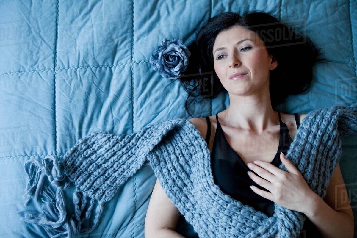 Woman laying on bed dreaming Stock Photo Dissolve