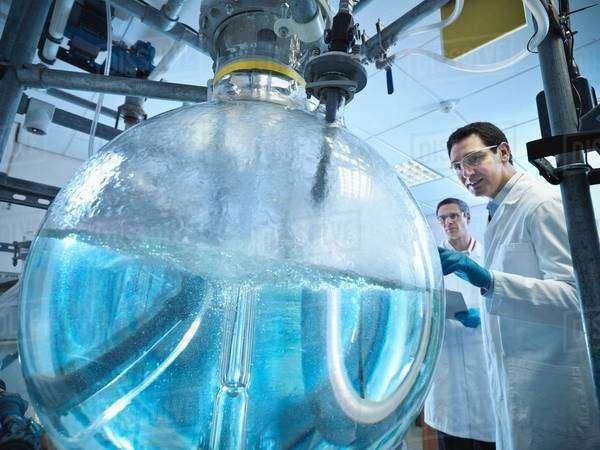 Scientists with laboratory mixing vessel - Stock Photo - Dissolve