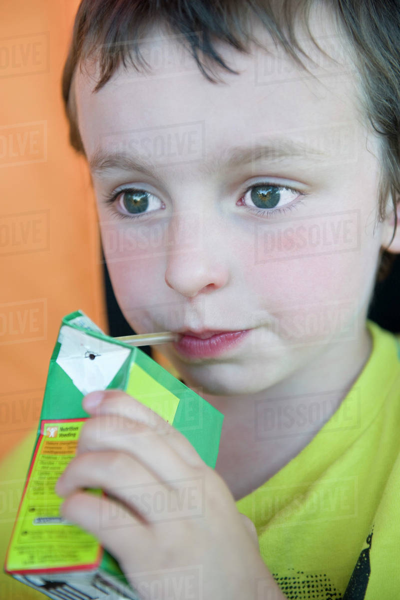 Little boy drinking juice box Stock Photo Dissolve