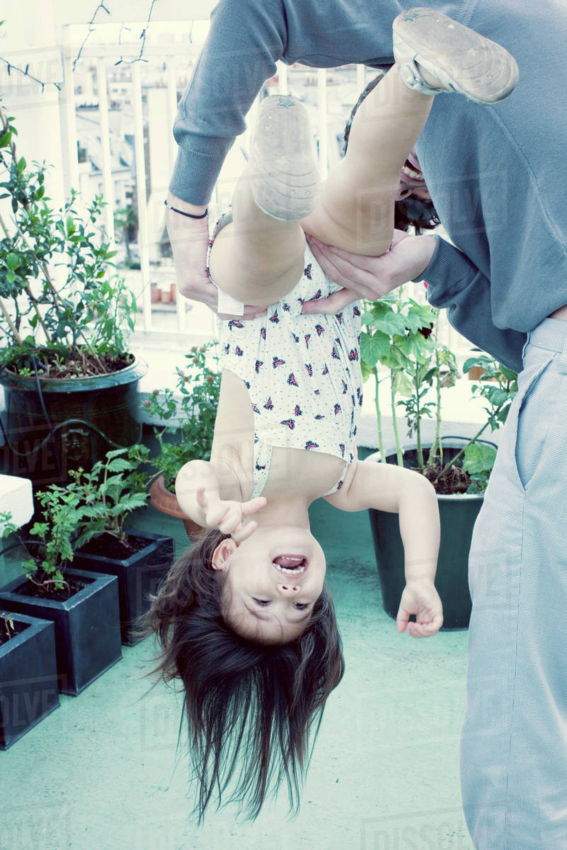 Father holding little girl upside down Stock Photo Dissolve