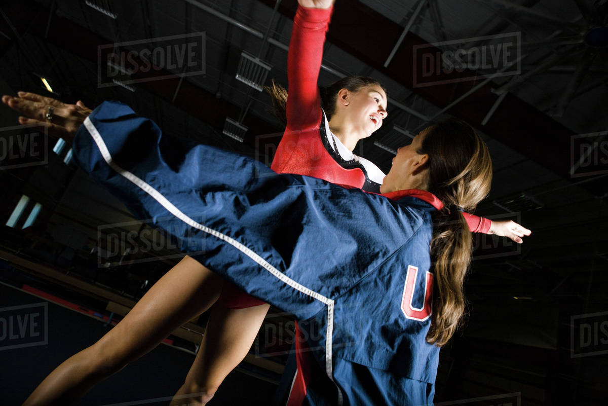 Female gymnast training with coach Stock Photo Dissolve