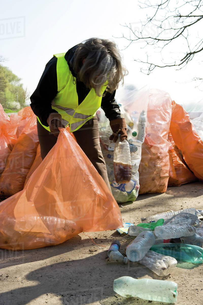 Woman collecting plastic bottles to recycle Stock Photo Dissolve
