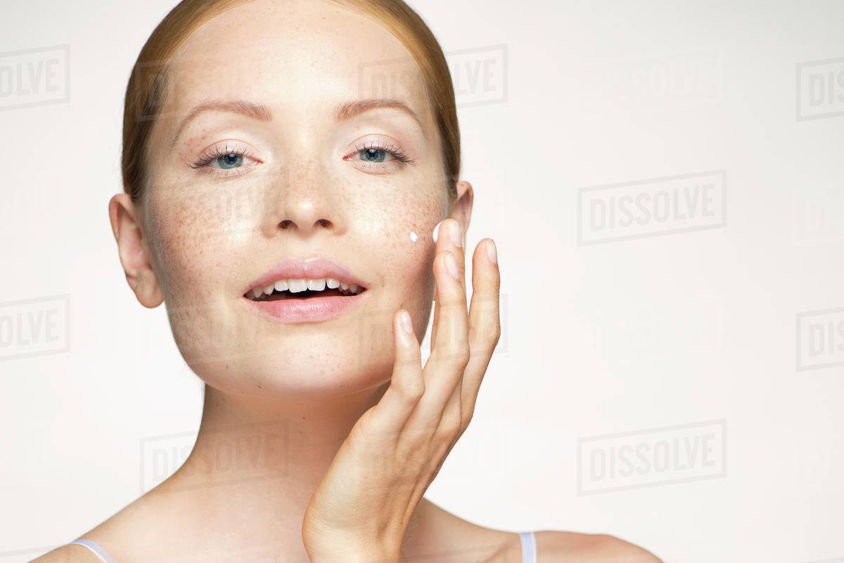 Woman moisturizing face Stock Photo Dissolve